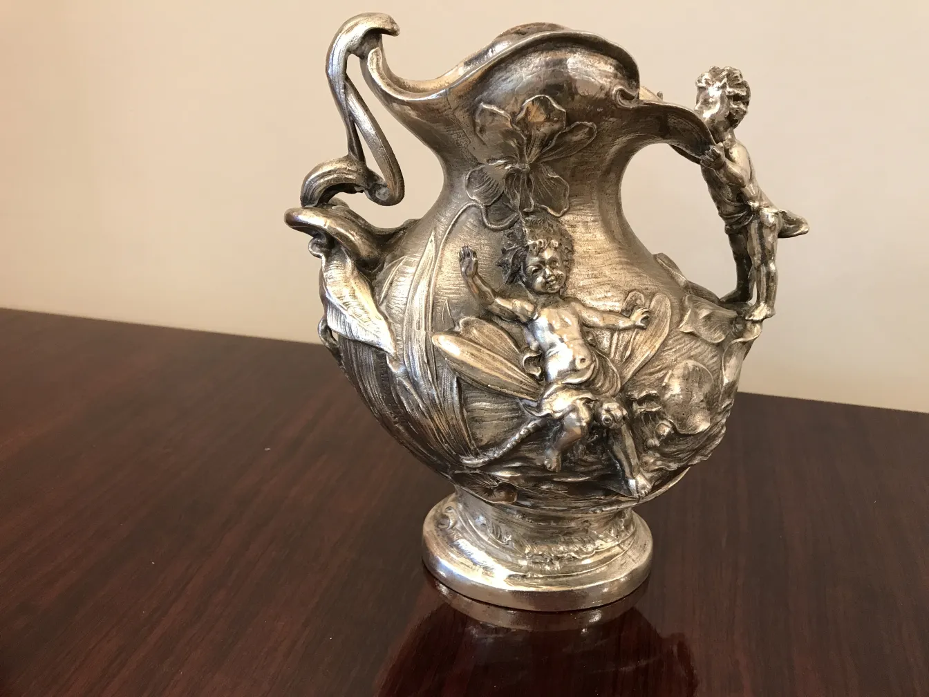 pichet ancien avec des figures sculptées élaborées