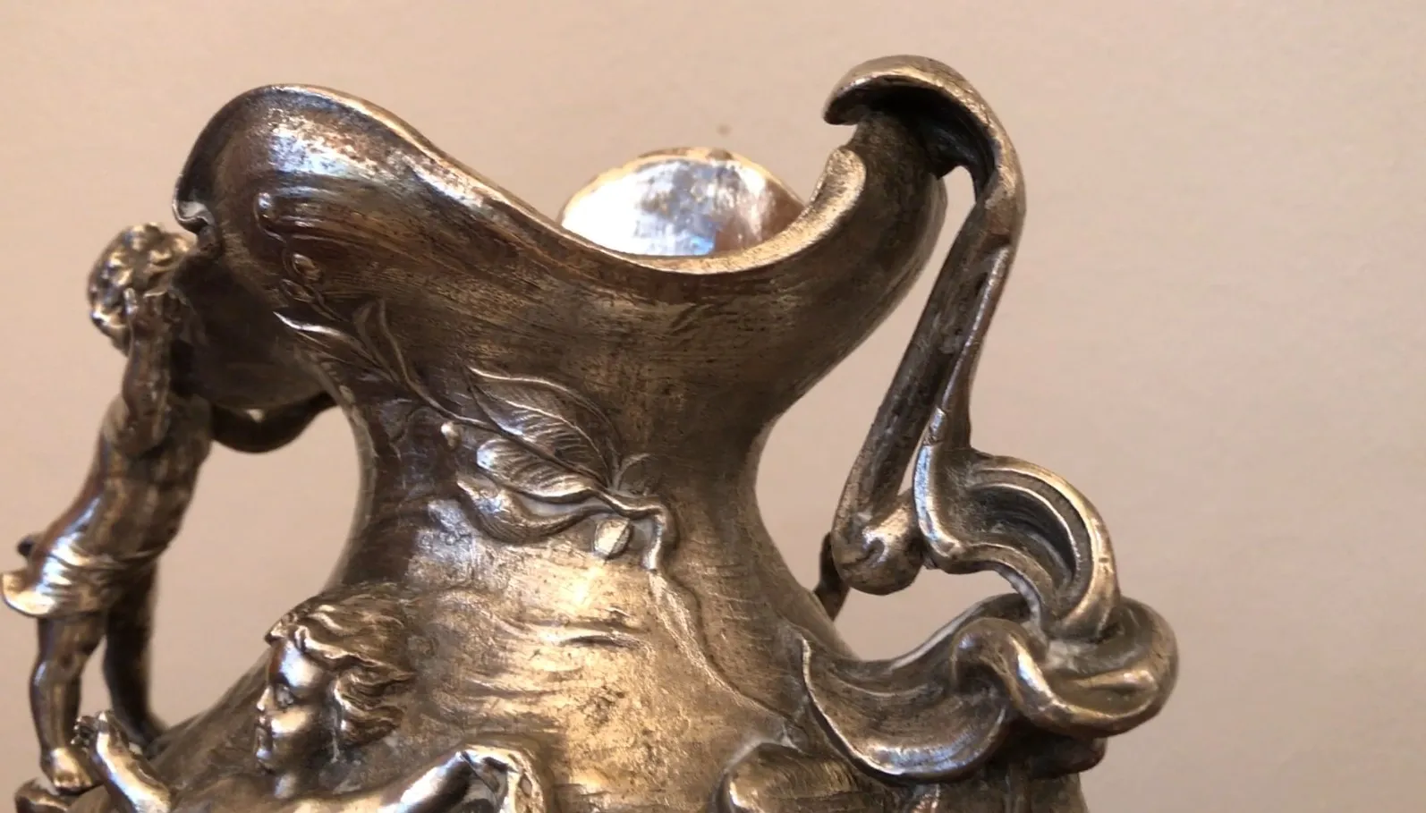 brocca antica con figure scolpite e design ornato