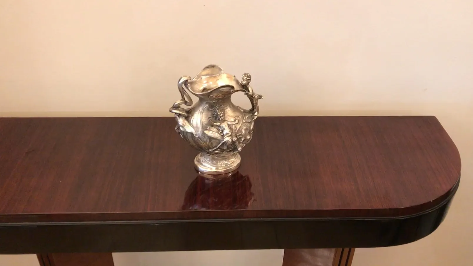 antigua jarra decorativa con detalles florales en una mesa de madera