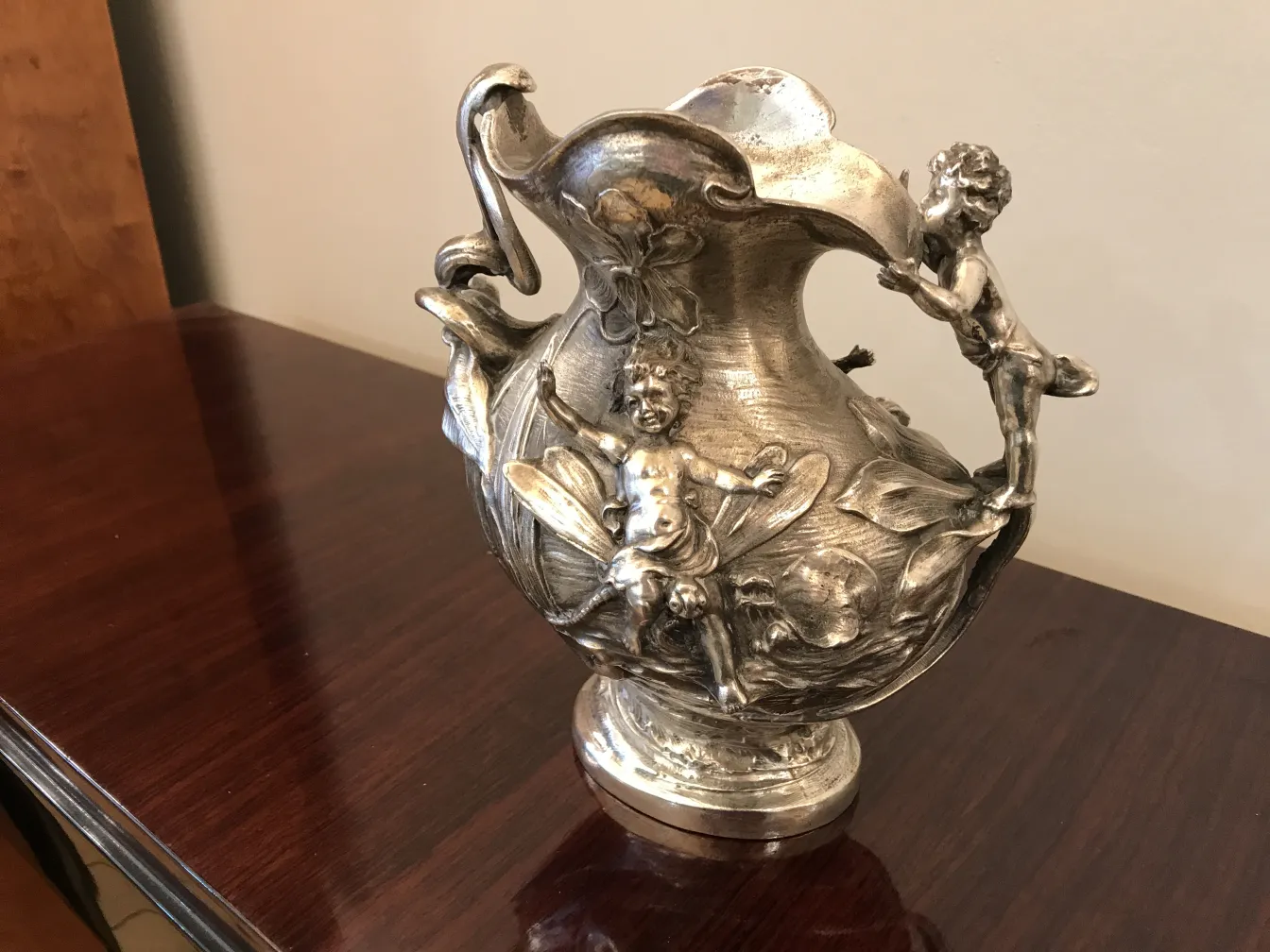 старинный кувшин, украшенный цветами и фигурами