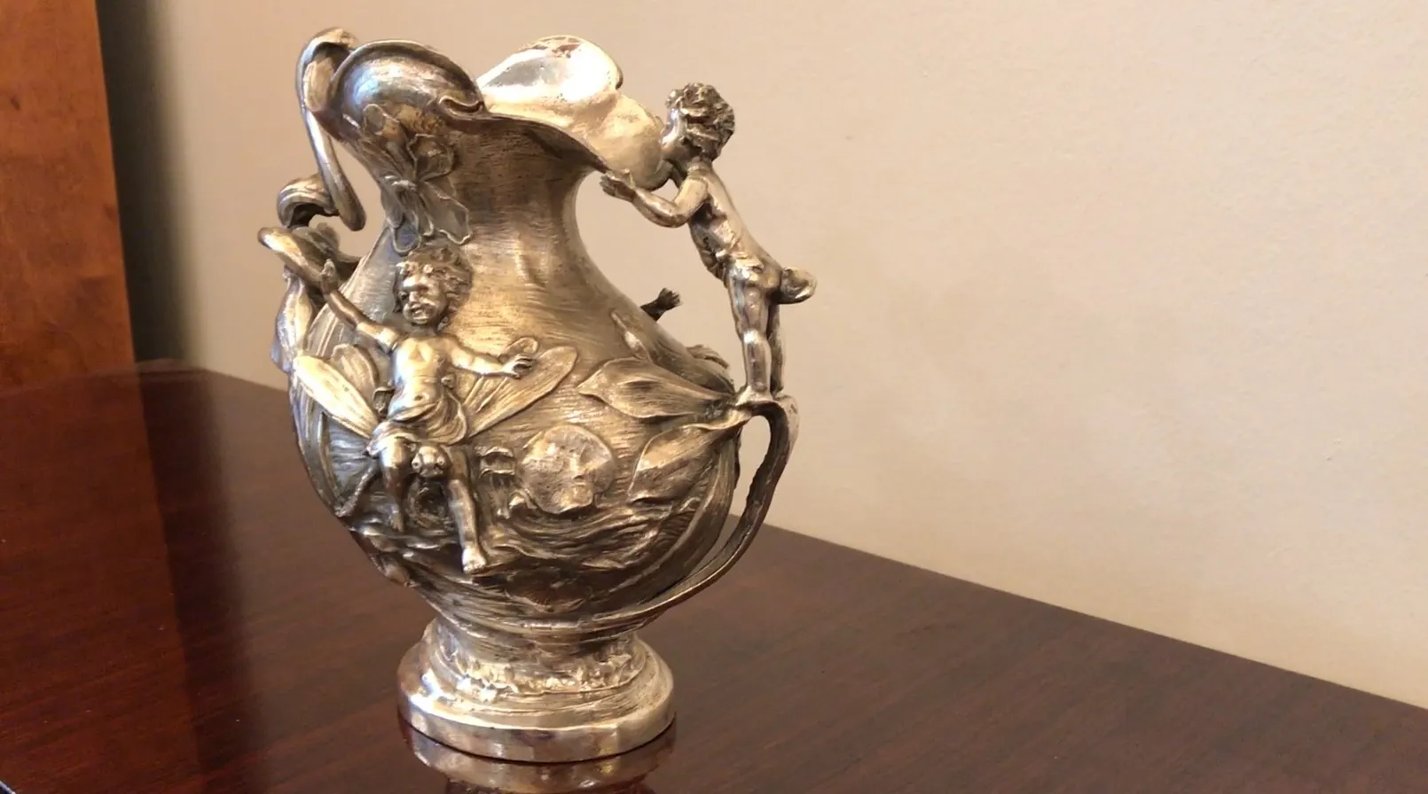 Старинный кувшин, украшенный фигурами детей.