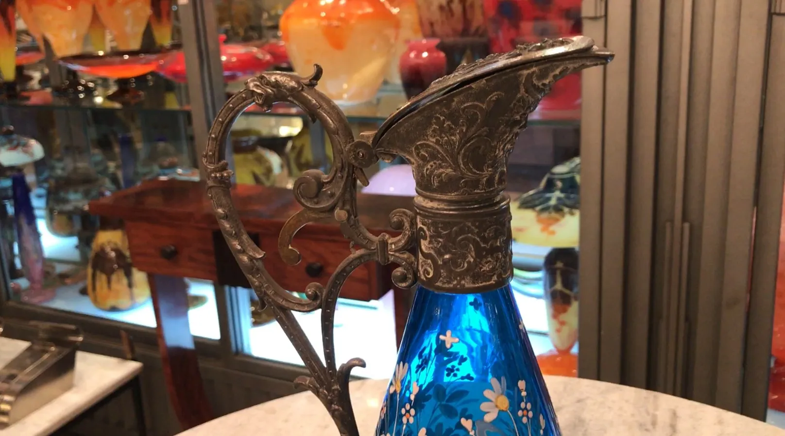 Antiker blauer wmfs krug mit dekorativer blume in eleganter umgebung.