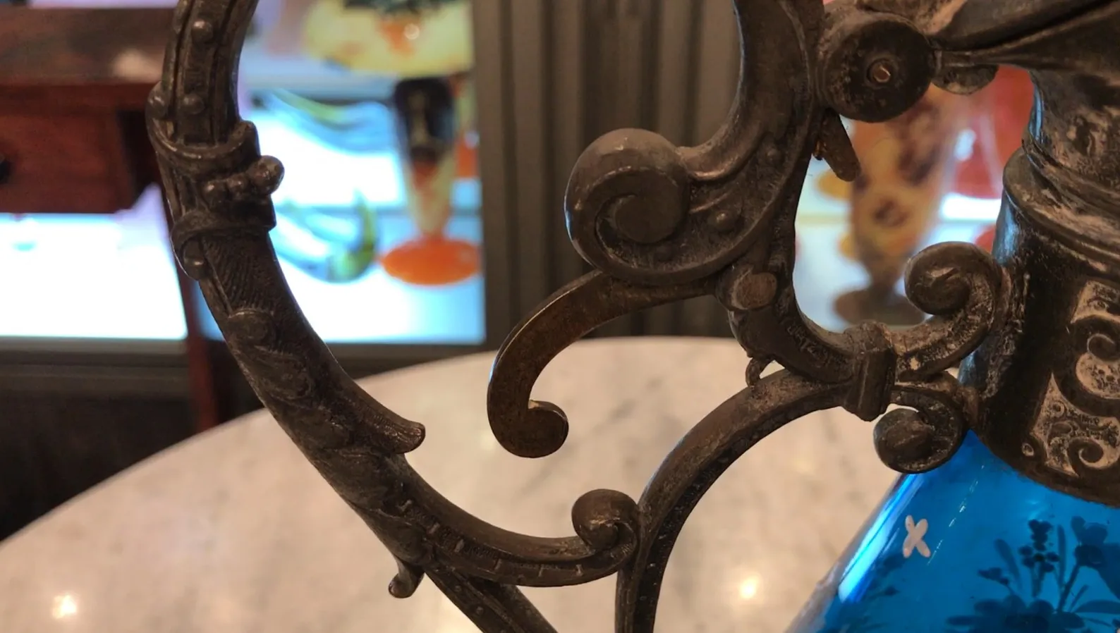 vista detalhada de duas jarras antigas WMF com detalhes ornamentais em um fundo de outros objetos antigos