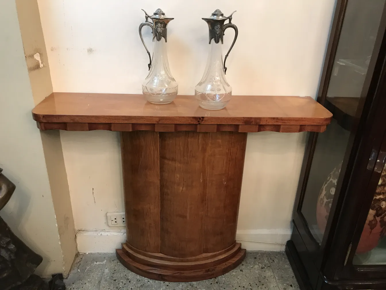 Duas jarras elegantes sobre uma mesa antiga, fundo neutro.