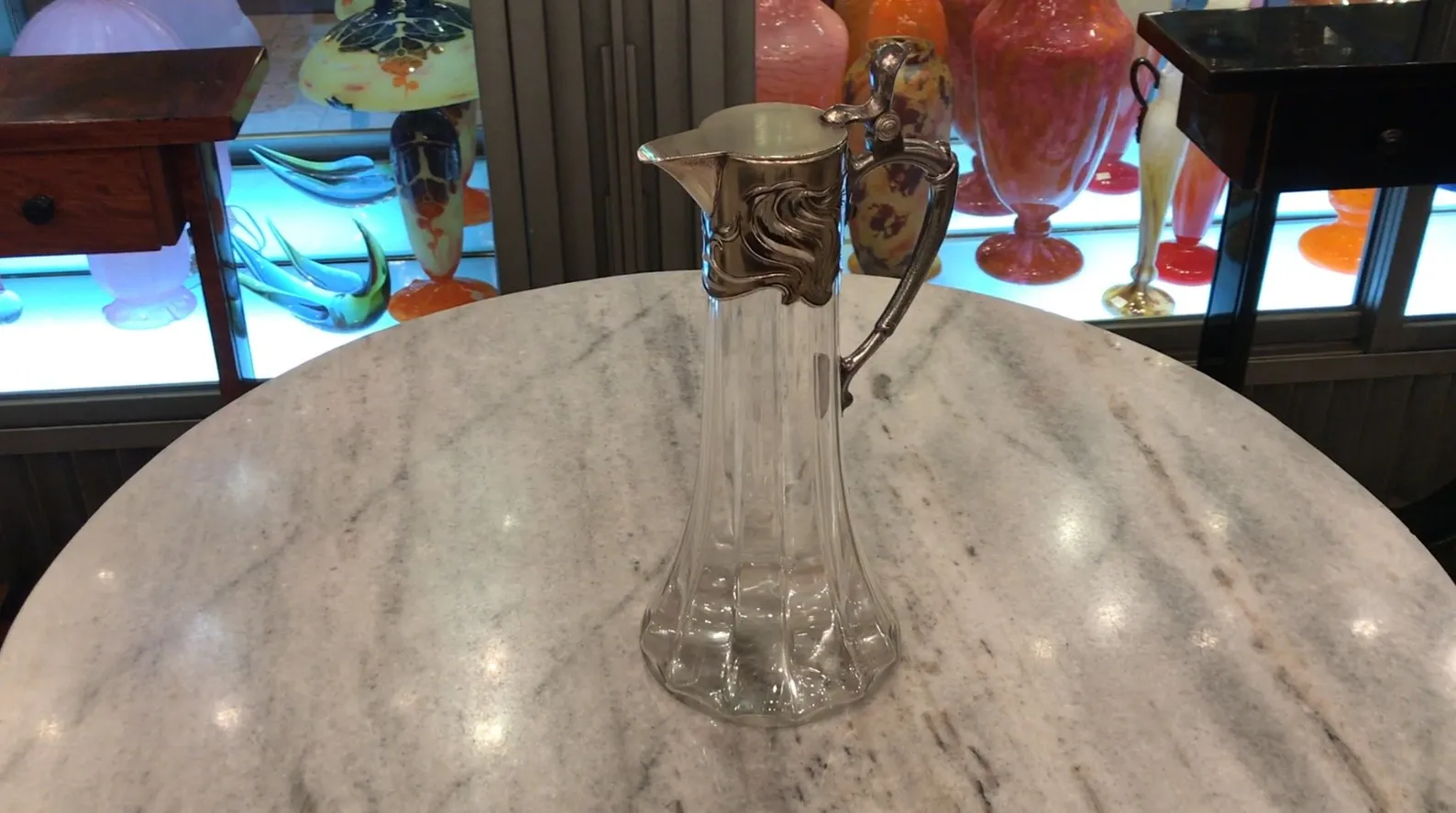 2 brocche antiche WMF su un tavolo in marmo con altri oggetti decorativi