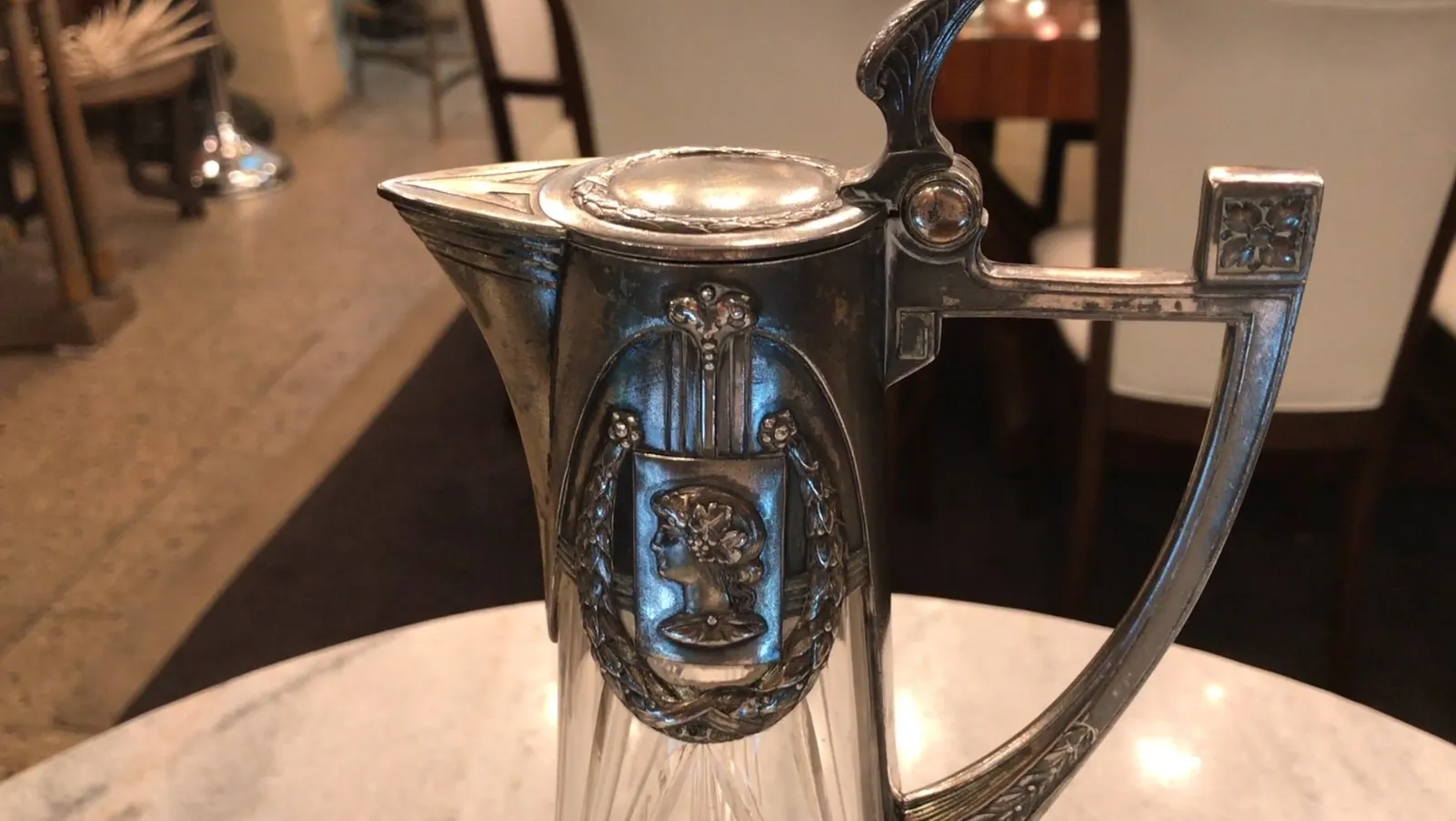 侧面视图中两个古老的WMF水瓶放在优雅的桌子上，背景是现代餐厅。