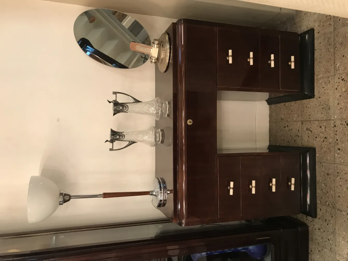 due brocche decorative antiche WMF con design unici, affiancate a una lampada e a uno specchio