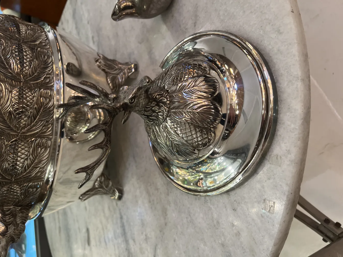 Ponchera WMF antigua con tapa con detalles de vida salvaje en un fondo elegante.