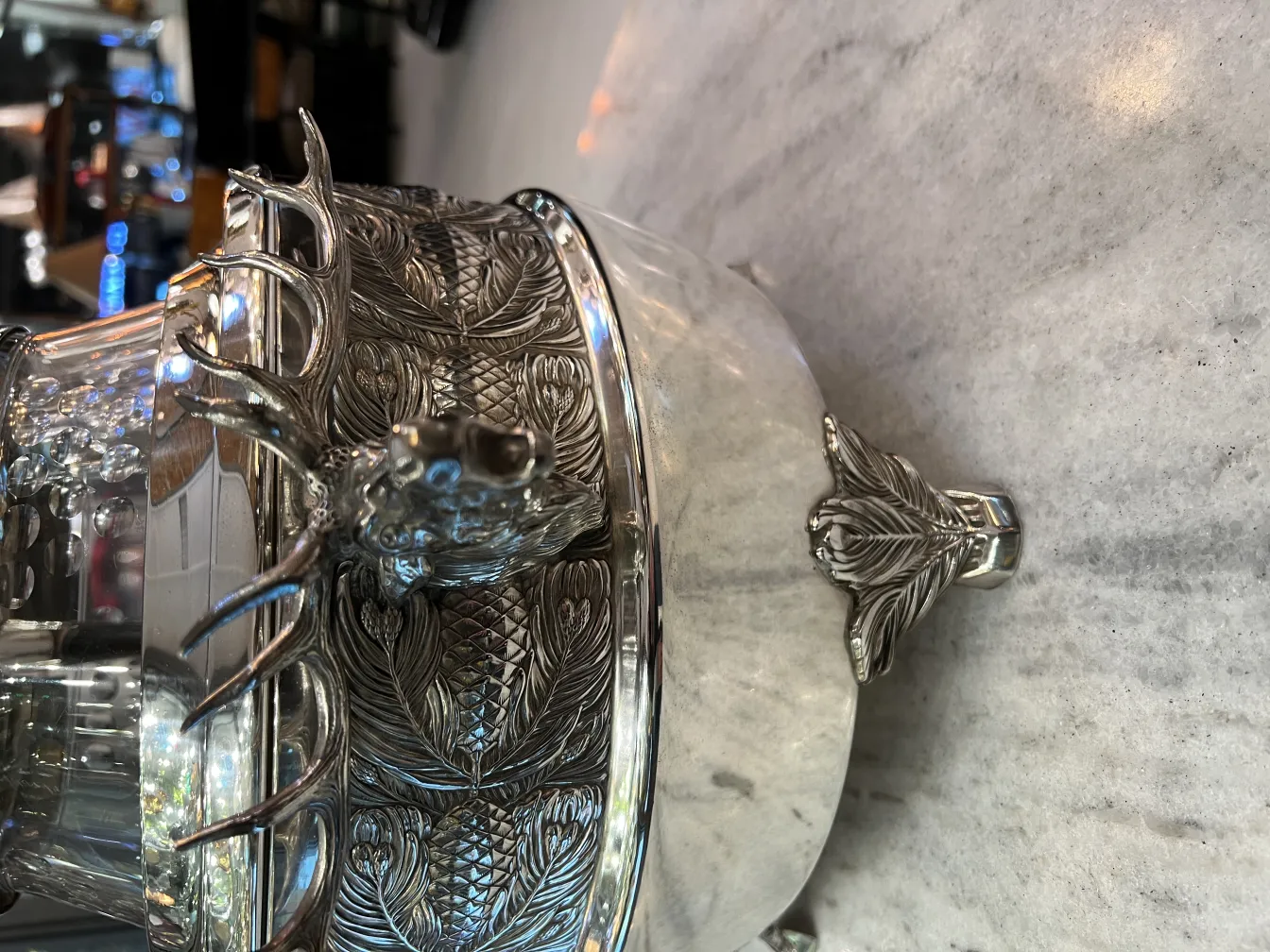 Antique WMF punch bowl featuring deer and leaf design, on a table