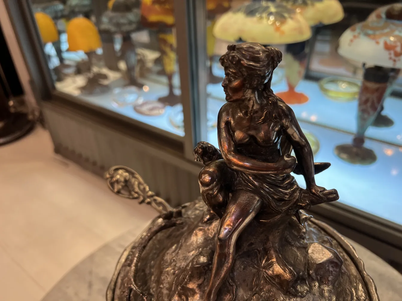 antique WMF punch bowl with sculptural scene on top, displayed in a vintage setting