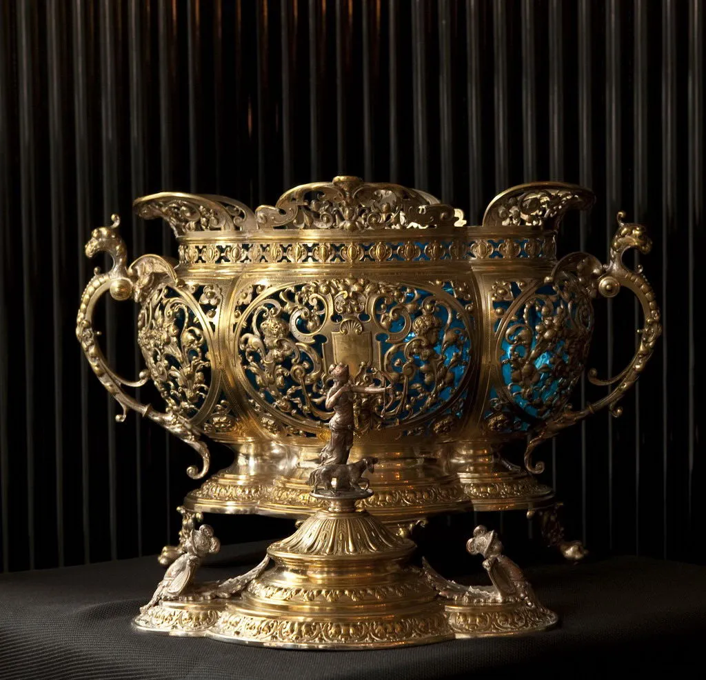 Poncheira antiga WMF com decoração elaborada e base detalhada em um ambiente escuro