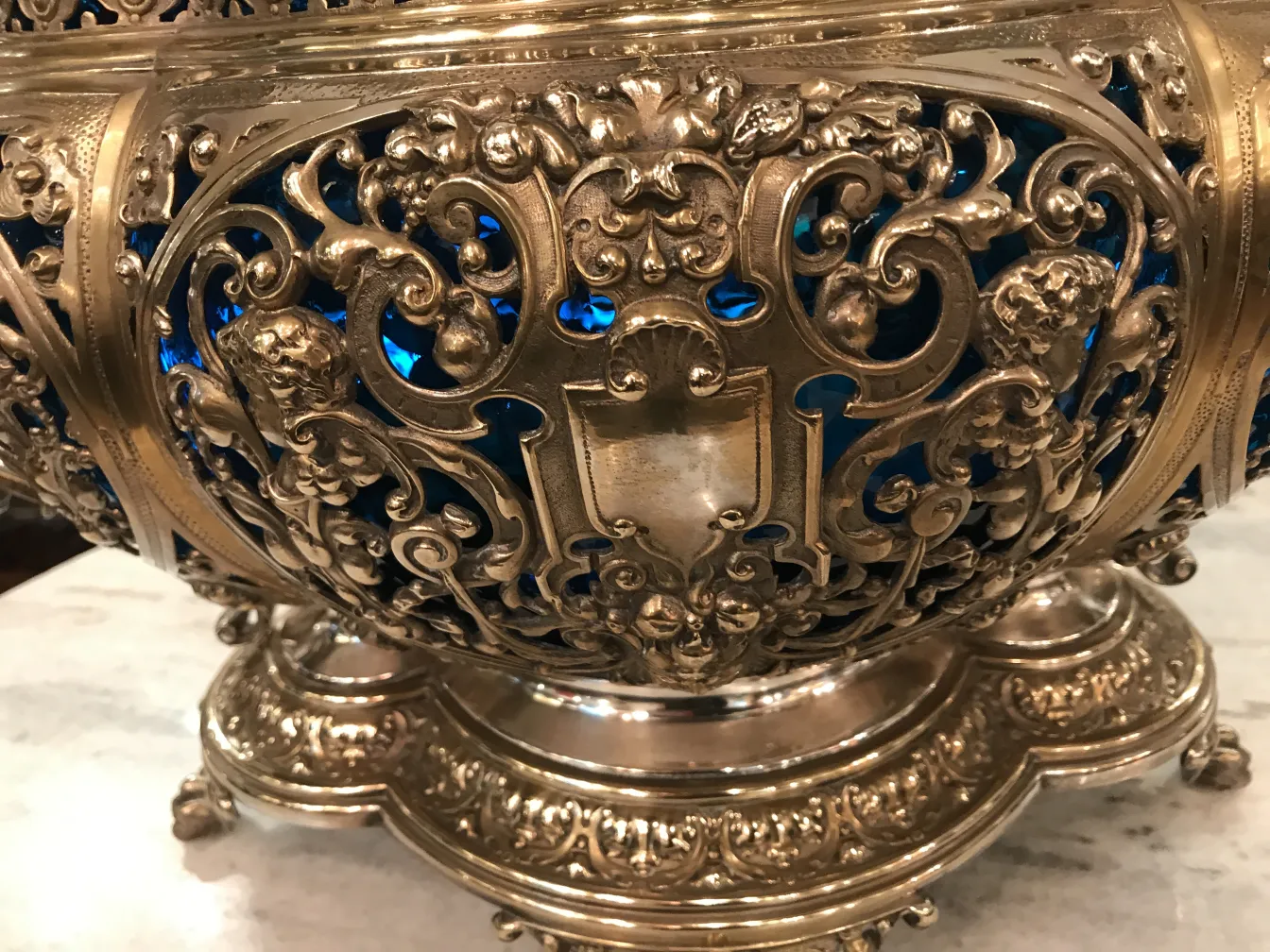 Vintage punch bowl WMF with ornate details and blue background.
