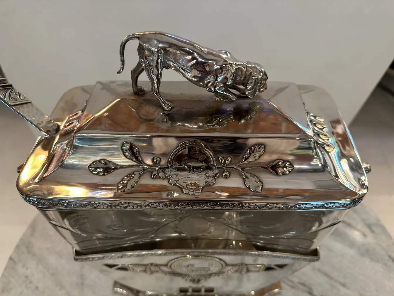 Antique WMF punch bowl featuring elegant design and dog detail on the lid, against a neutral background.