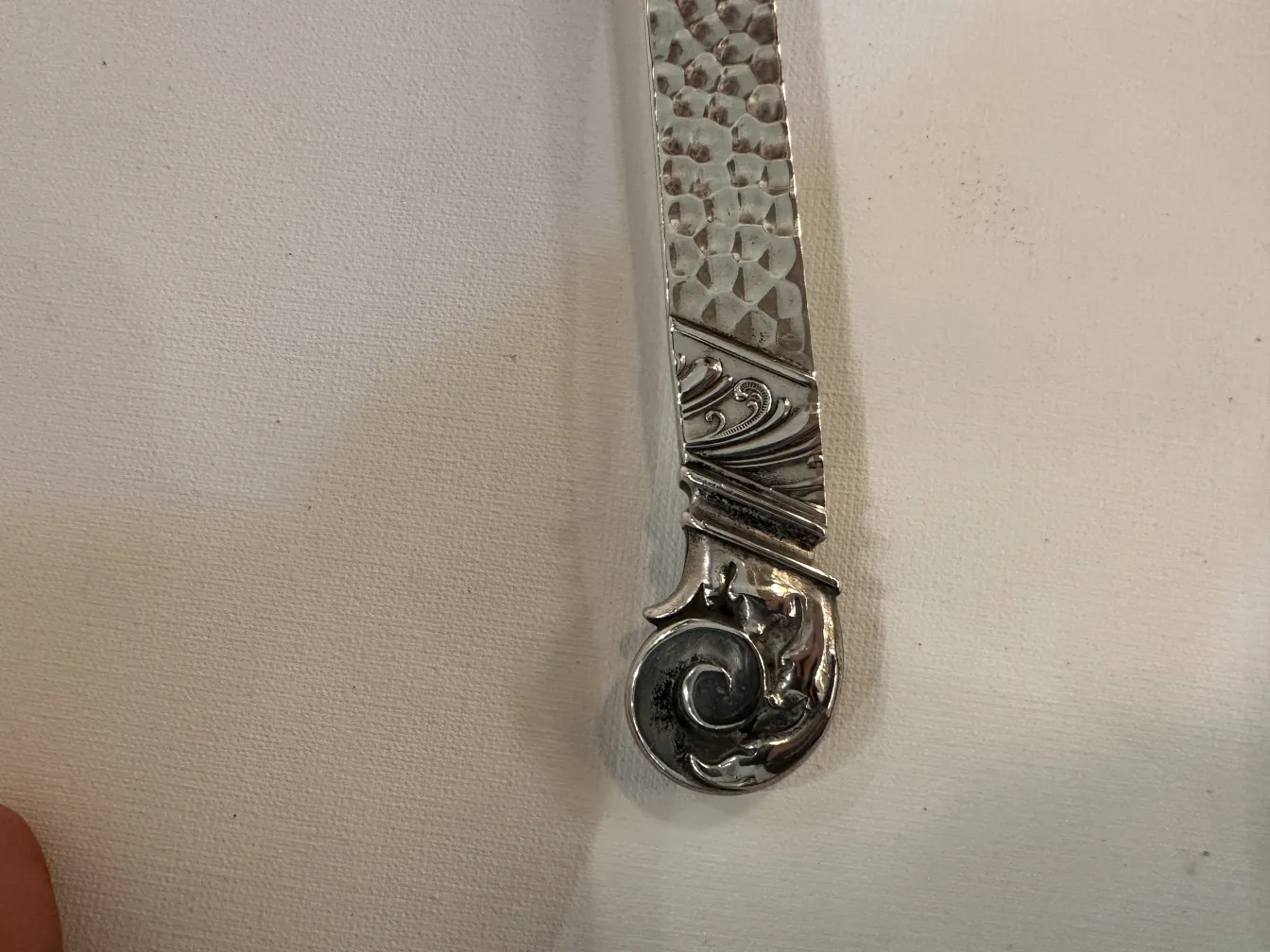 Poncheira antiga WMF com finas decorações na alça, fundo branco.