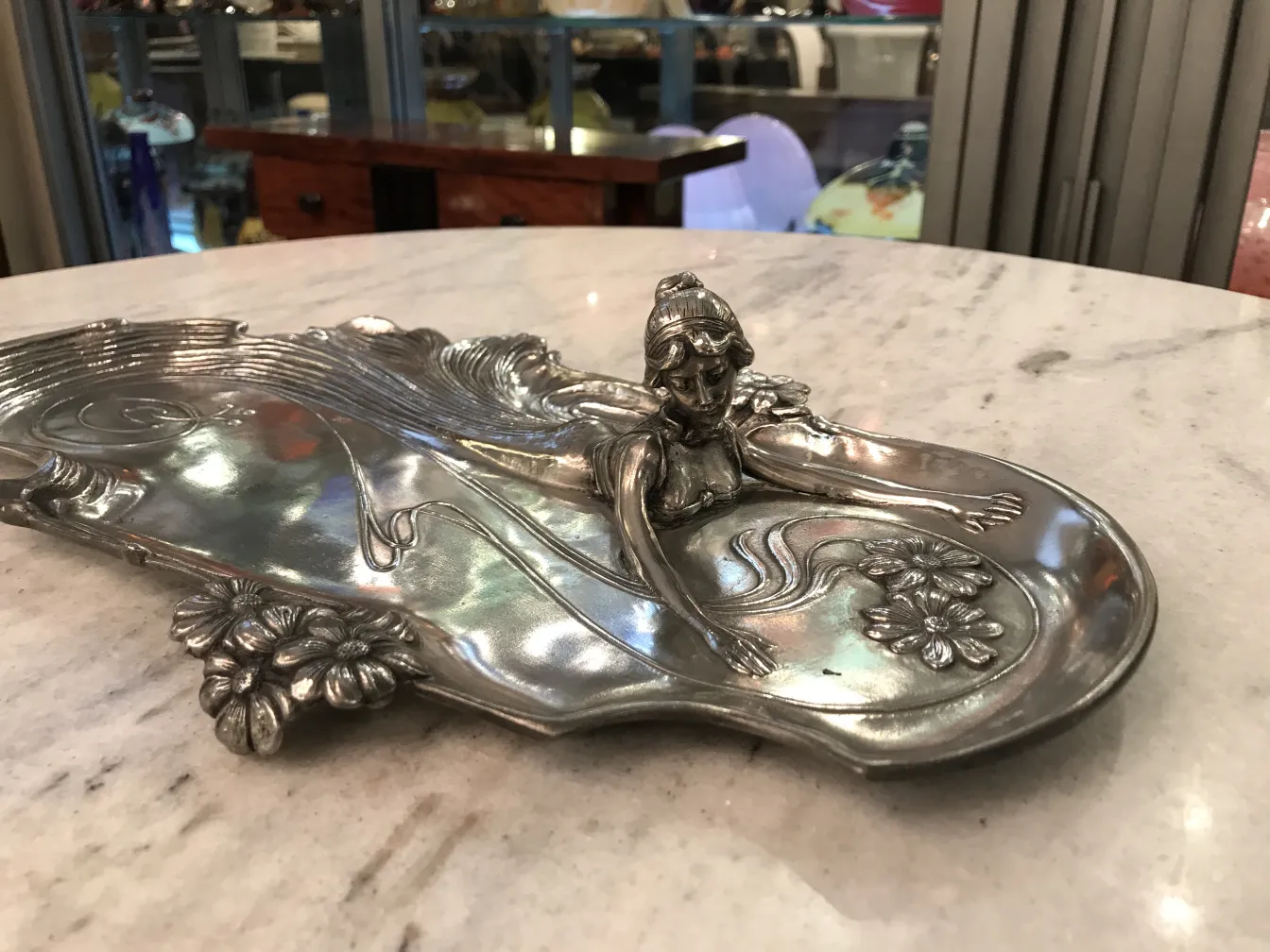 bandeja de cartas antigua WMF con figura decorativa y flores en un fondo elegante.