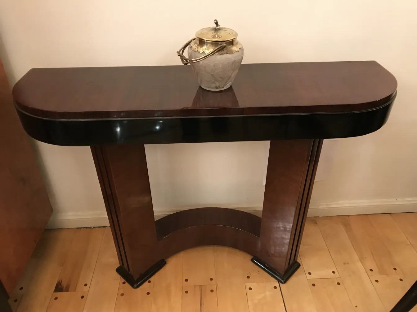 Bonbonnière antique décorative sur une table élégante avec fond simple.