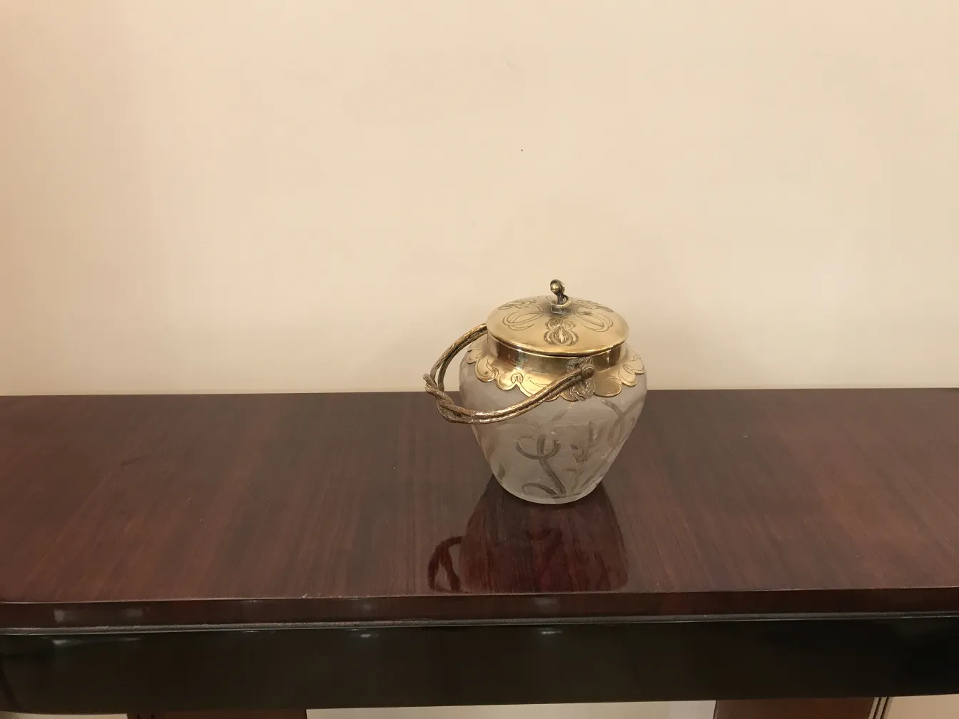 علبة حلوى قديمة مزينة مع غطاء على طاولة خشبية