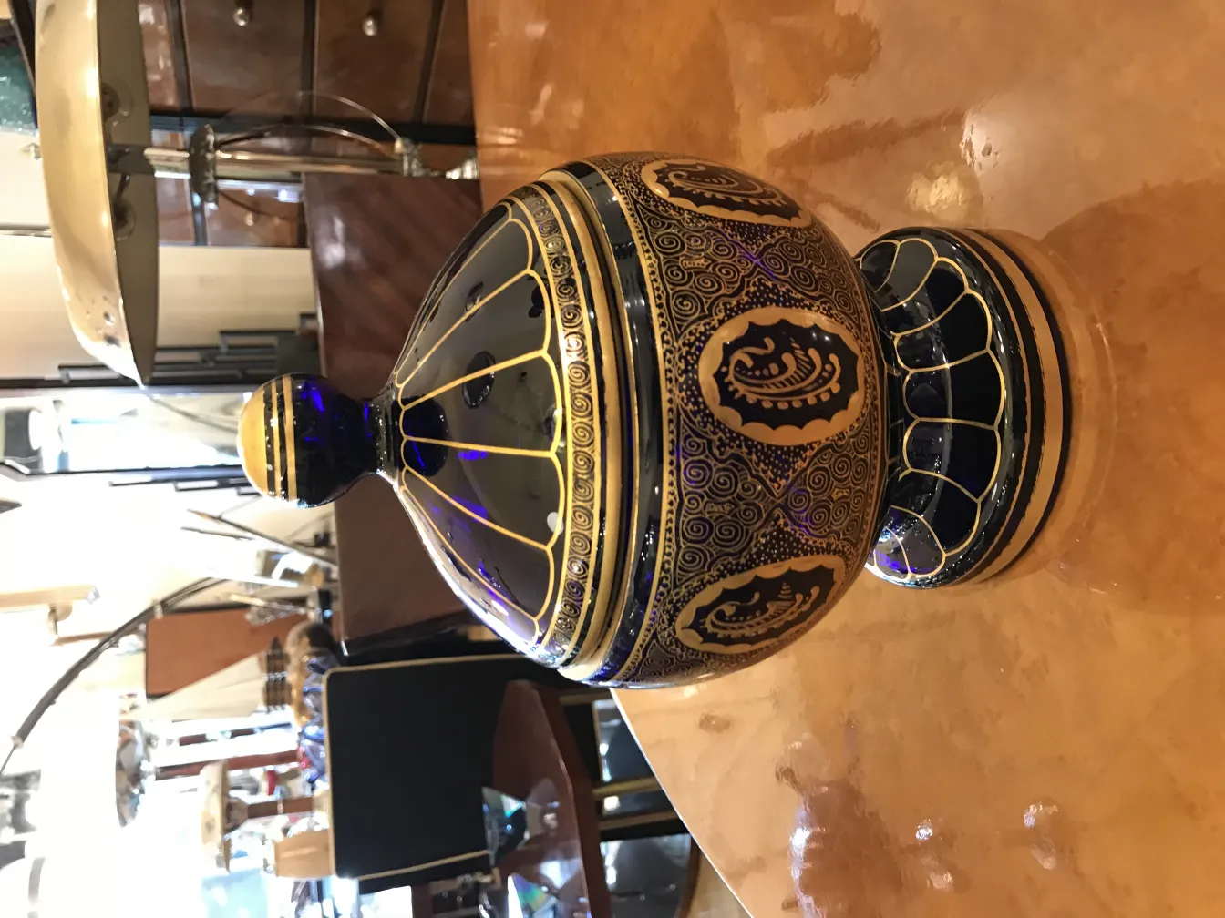 光沢のあるテーブルの上に青と金のパターンを持つ古いキャンディボックス