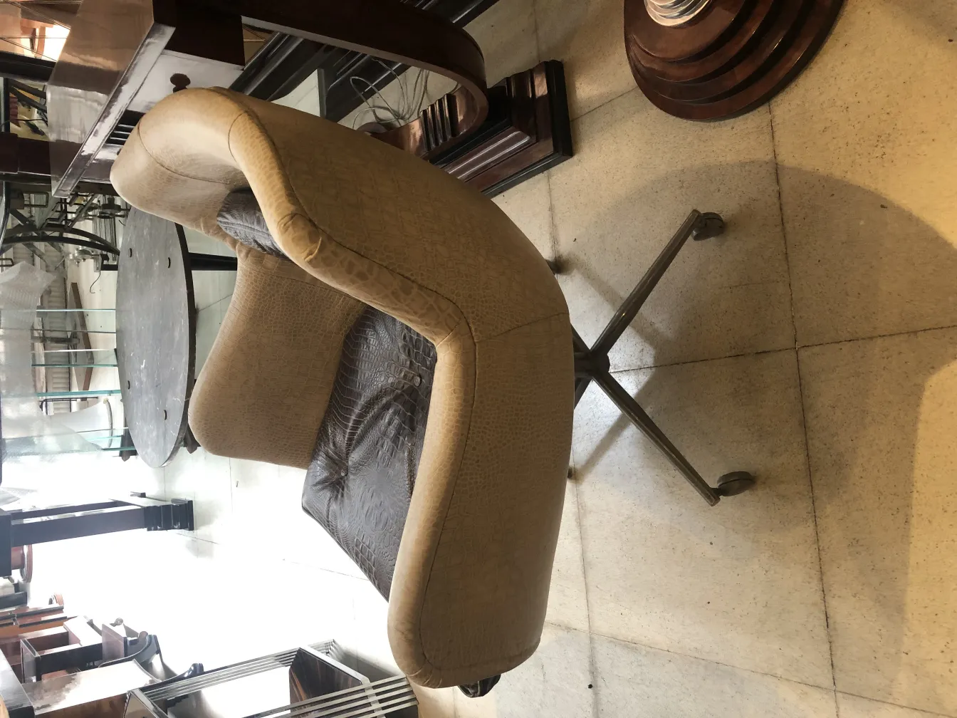 Poltrona antica morbida di colore beige con ruote alla base.