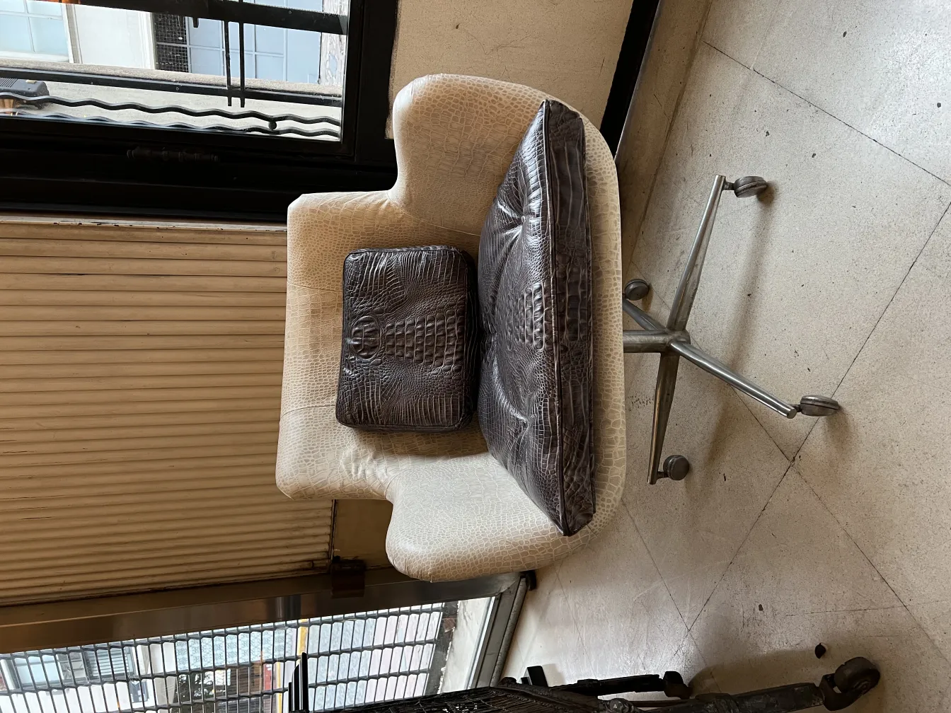 Sillón antiguo con diseño ergonómico y cojín decorativo en un ambiente elegante.