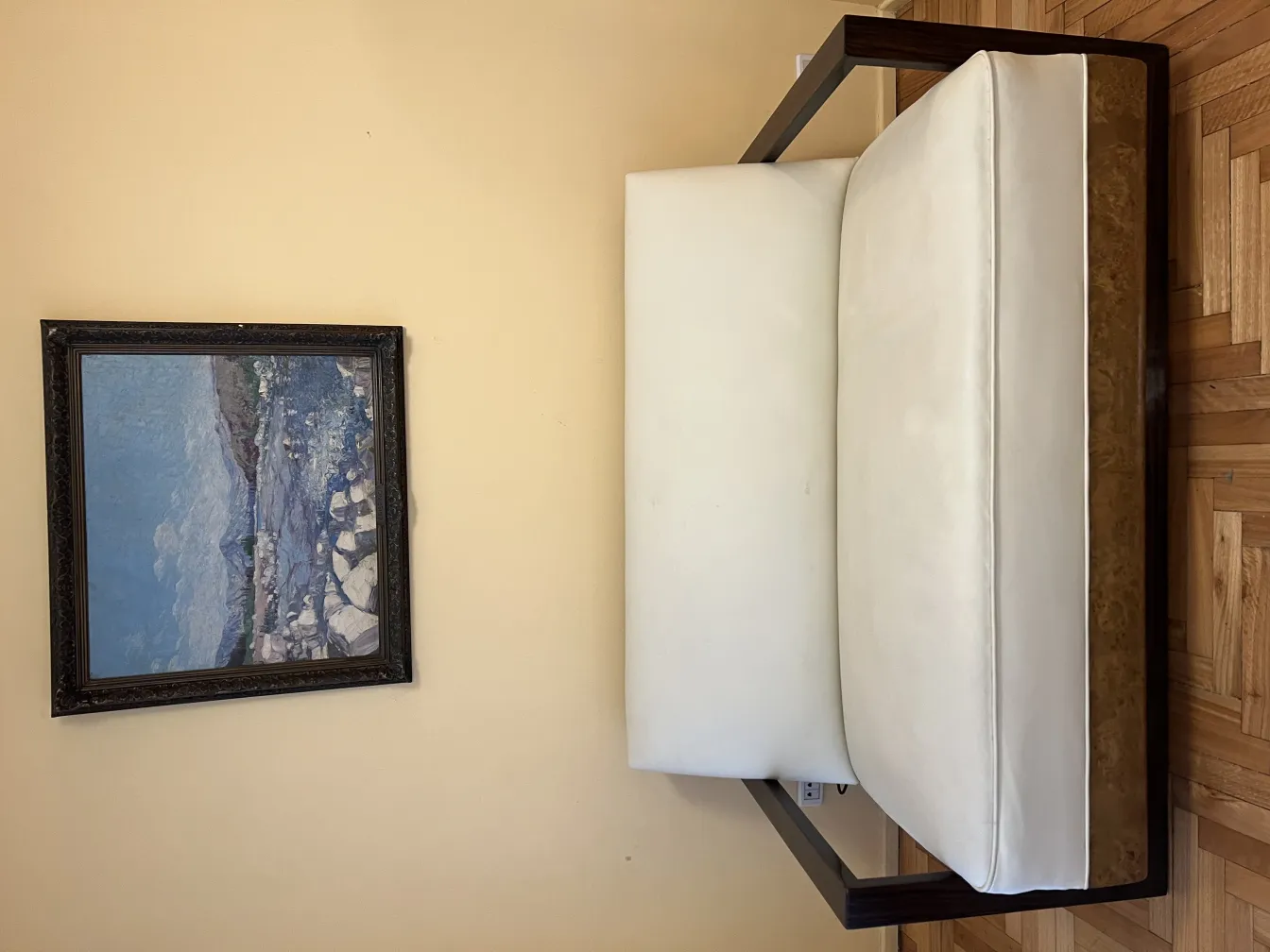 पुराना हल्का रंग का आर्मचेयर, जो आरामदायक वातावरण में है।