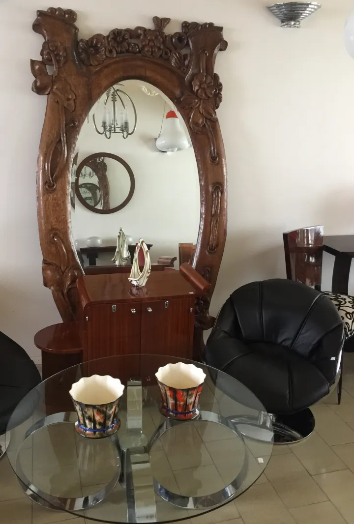 Two antique armchairs in Madrid, featuring a decorative mirror and a glass table.