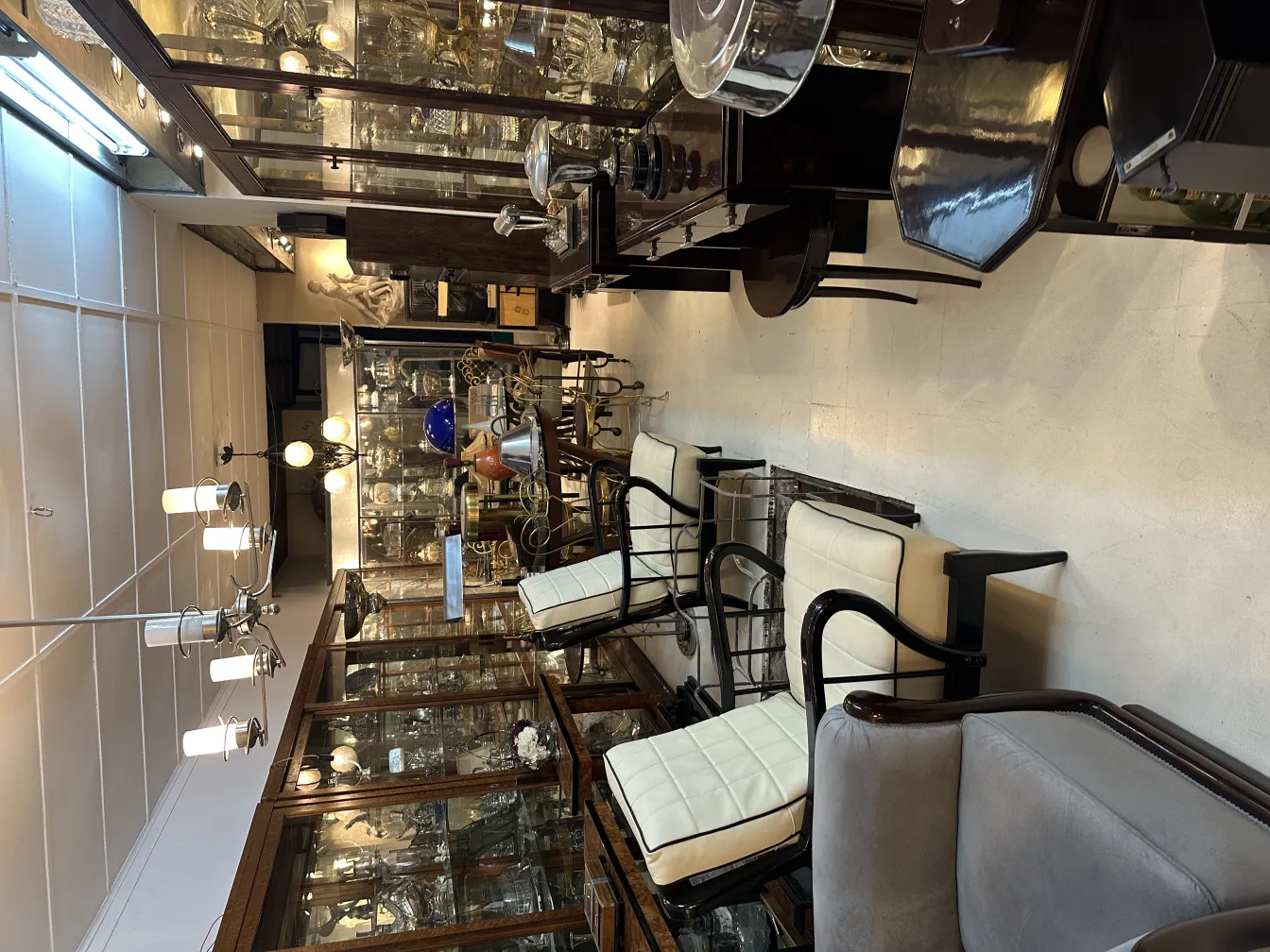 two antique armchairs with light cushions in an antique shop setting