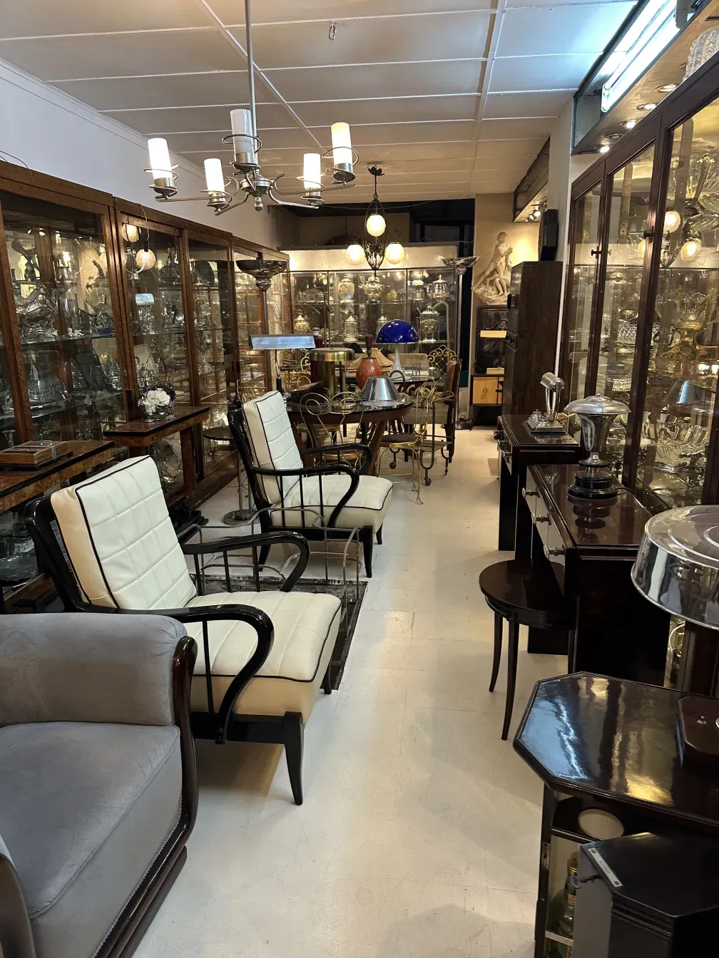 deux fauteuils anciens de Paolo Buffa dans une pièce avec des vitrines