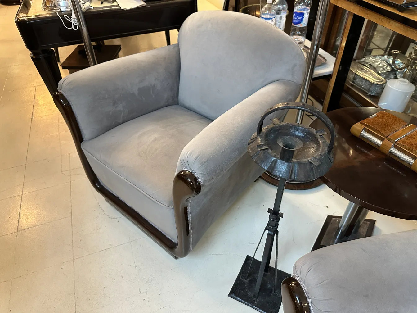 2 antique armchairs in an elegant setting, with a table and accessories