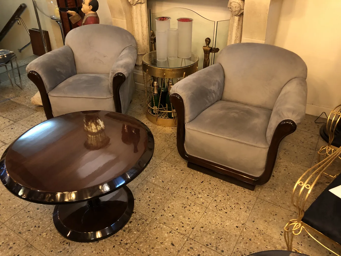Duas poltronas antigas cinzas, macias e elegantes, decoração estilosa com mesa de café.