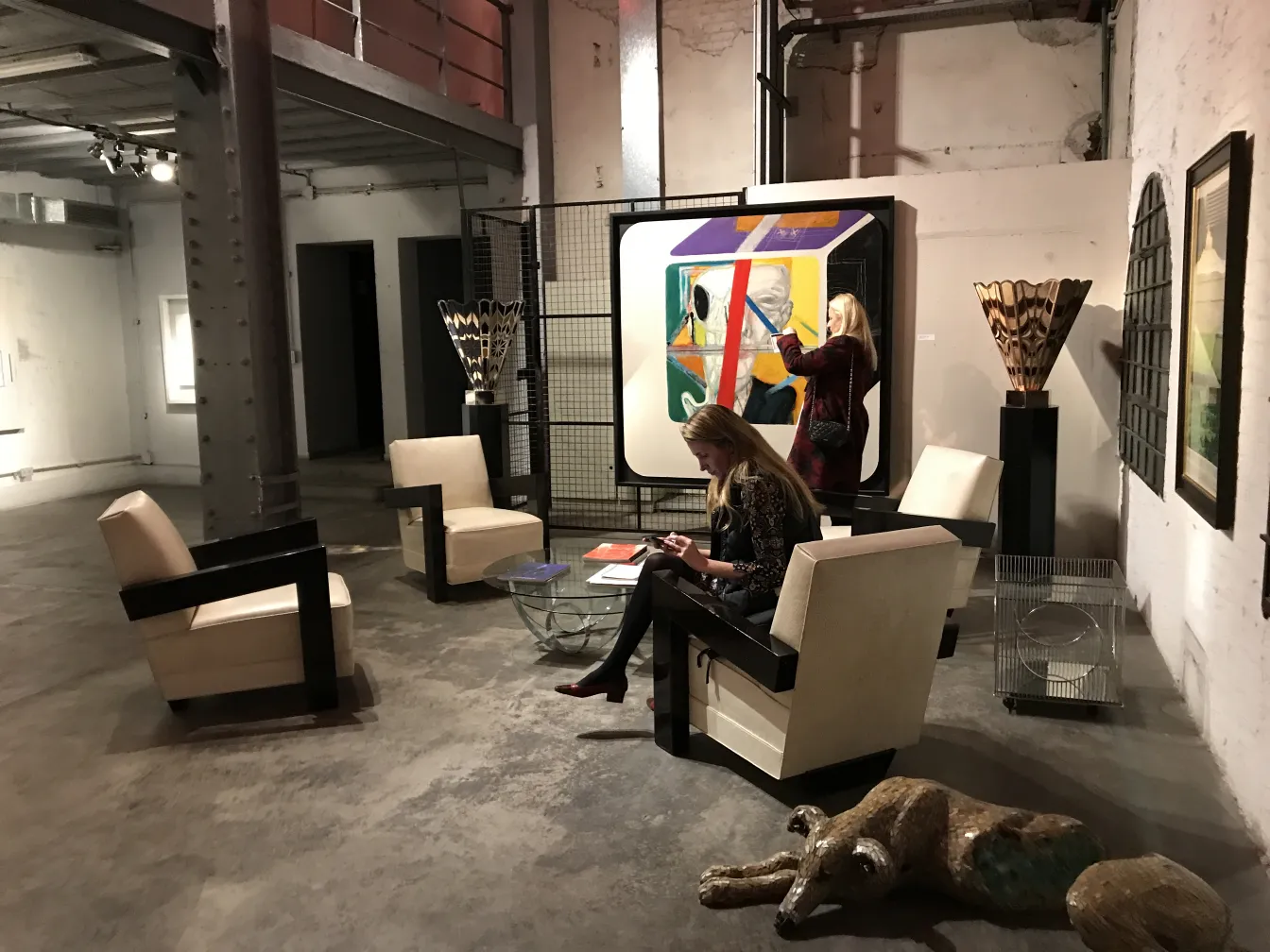 two antique armchairs in a gallery with a glass table
