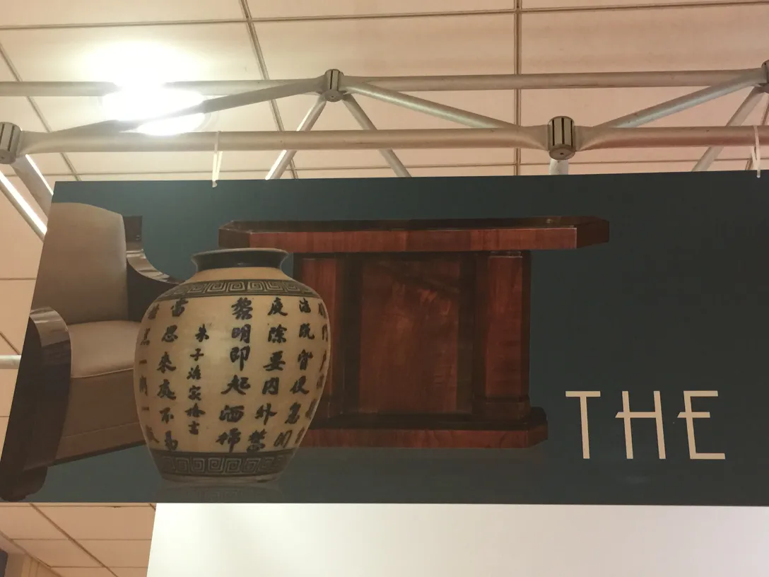 Deux fauteuils anciens, avec un vase décoratif et une table en arrière-plan.