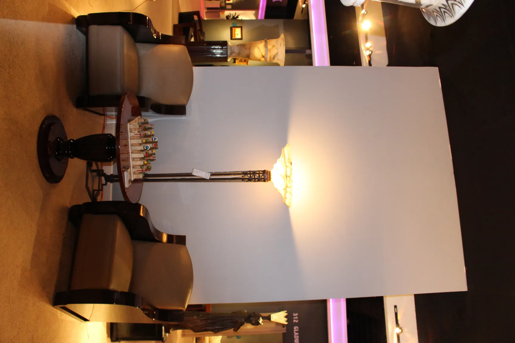 two antique armchairs in a cozy space, with a lamp and table