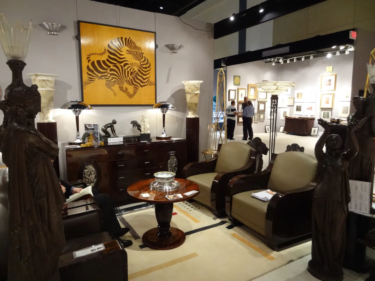 Duas poltronas antigas com design clássico em um ambiente elegante, cercadas de arte.