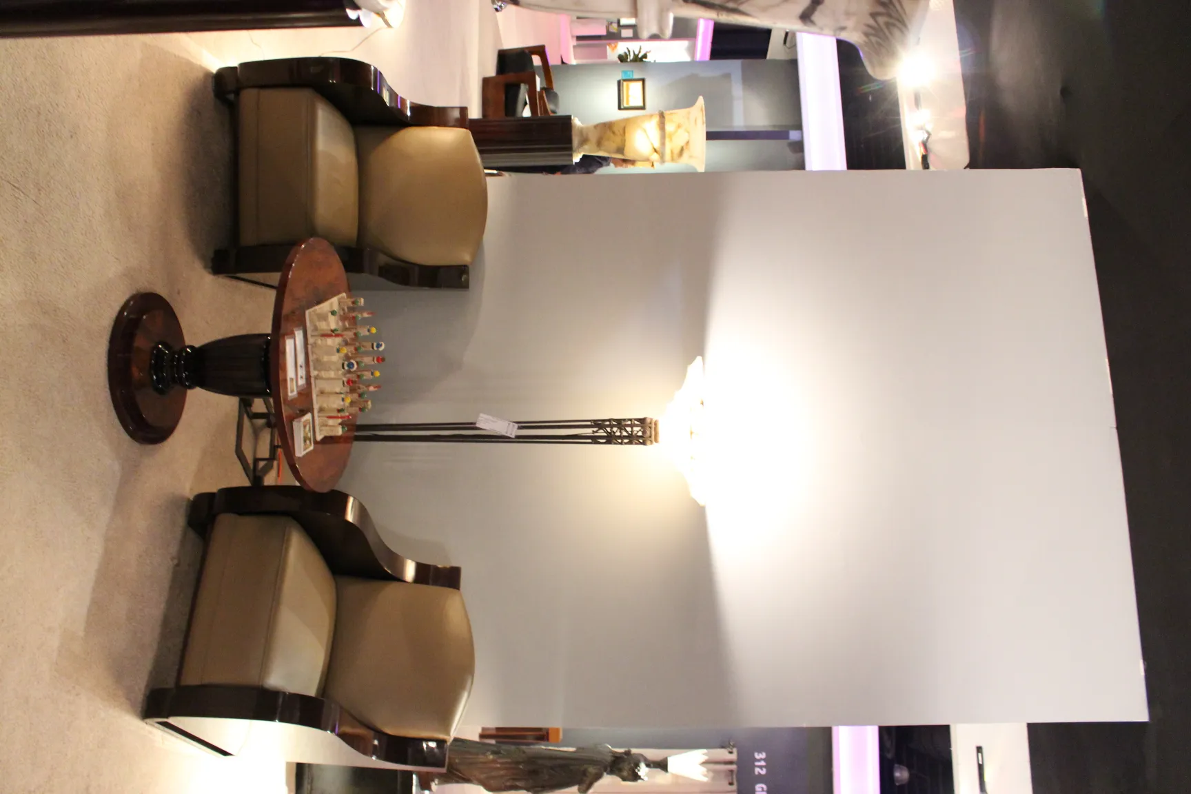 Deux fauteuils anciens confortables au design chaleureux, à côté d'une table et d'une lampe.