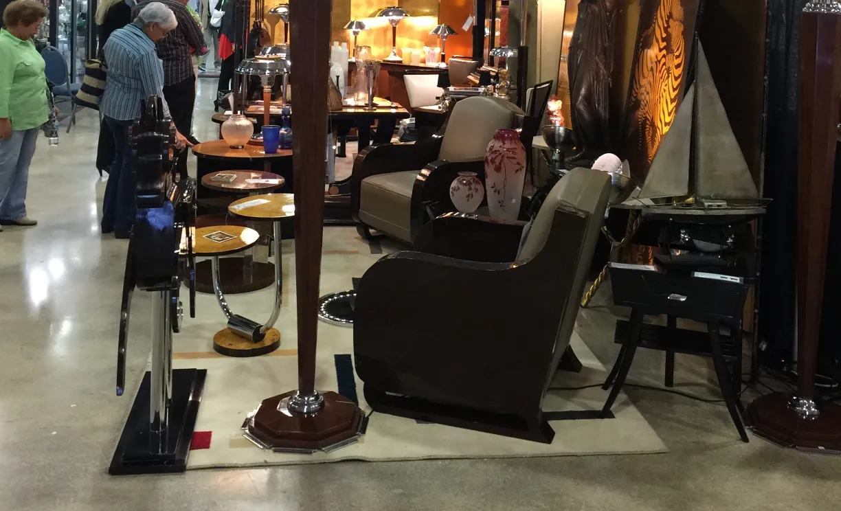 two antique armchairs in a display with lamps and decor