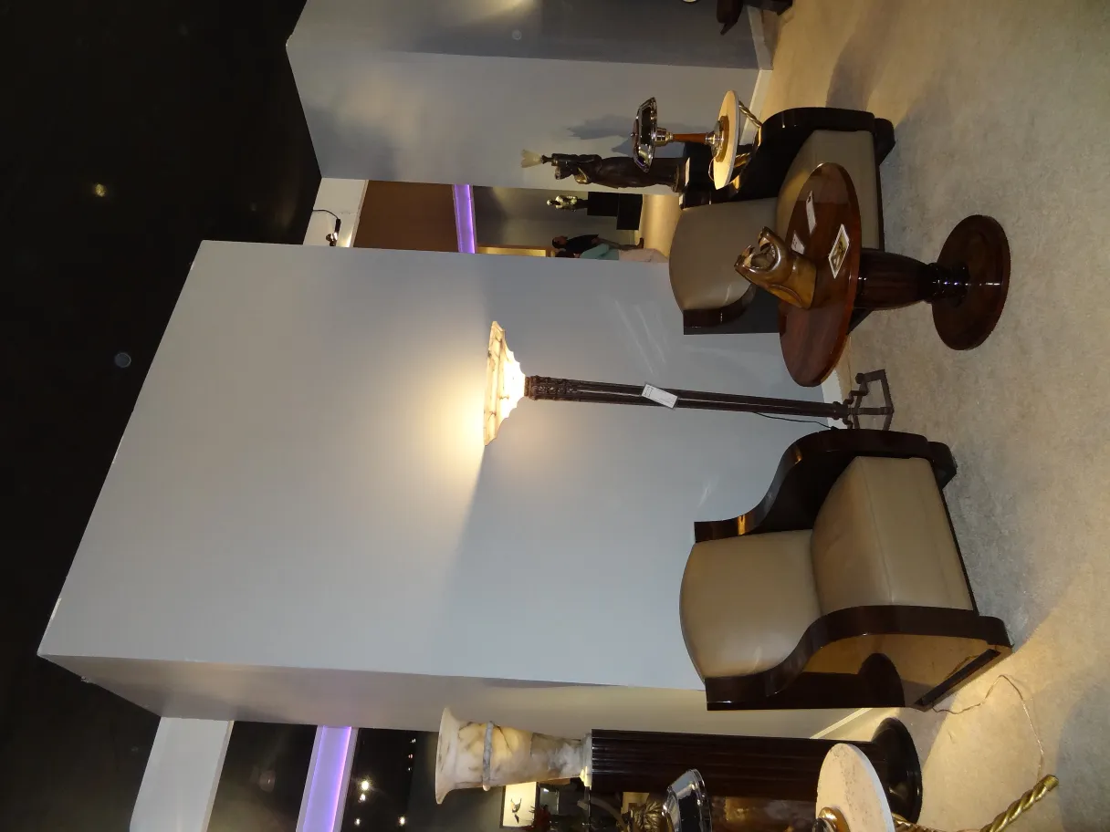 two antique armchairs with a distinctive and elegant design, in a decorated environment with a lamp and tables