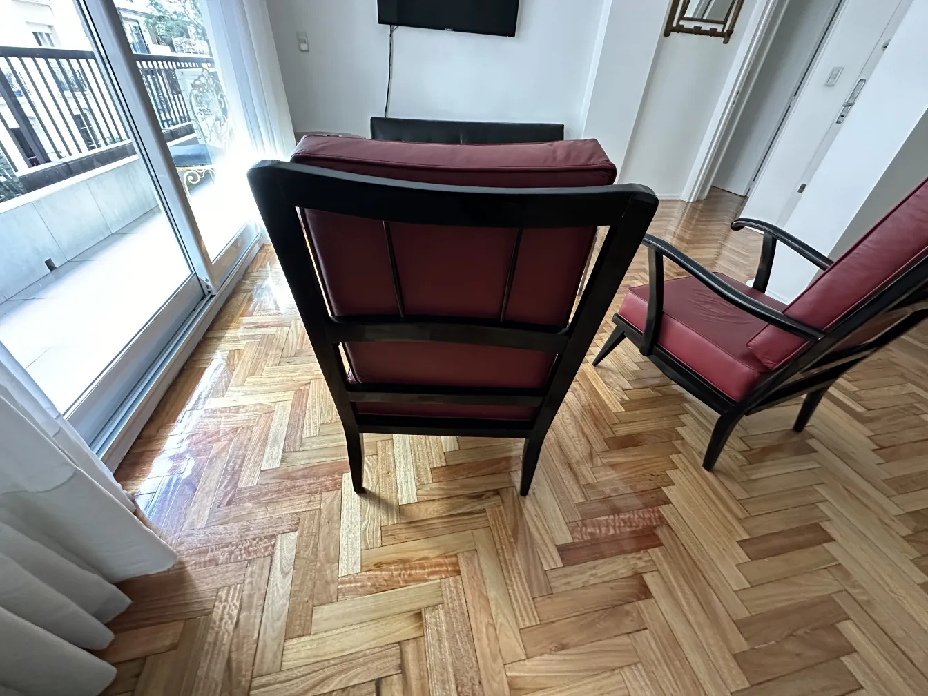 Vue de 2 fauteuils anciens dans une pièce avec lumière naturelle