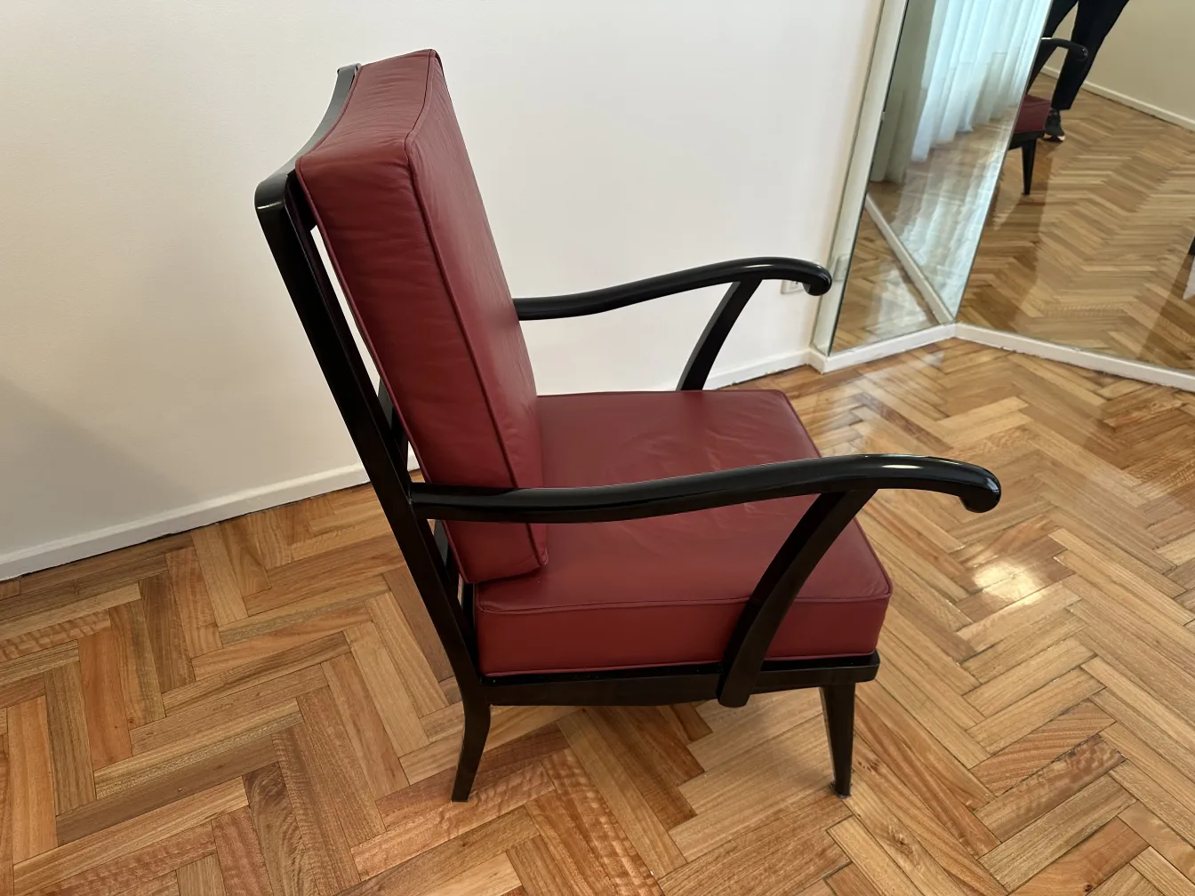 Zwei antike Armlehnstühle mit bordeauxfarbenem Stoff, gut erhalten und elegantes Design in einer gemütlichen Umgebung.