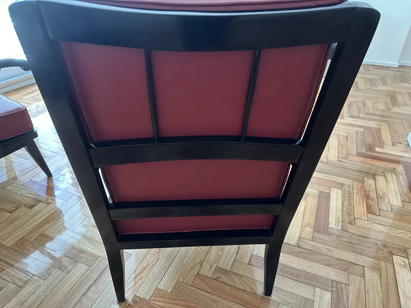 Vista trasera de dos antiguos sillones en un ambiente cálido.