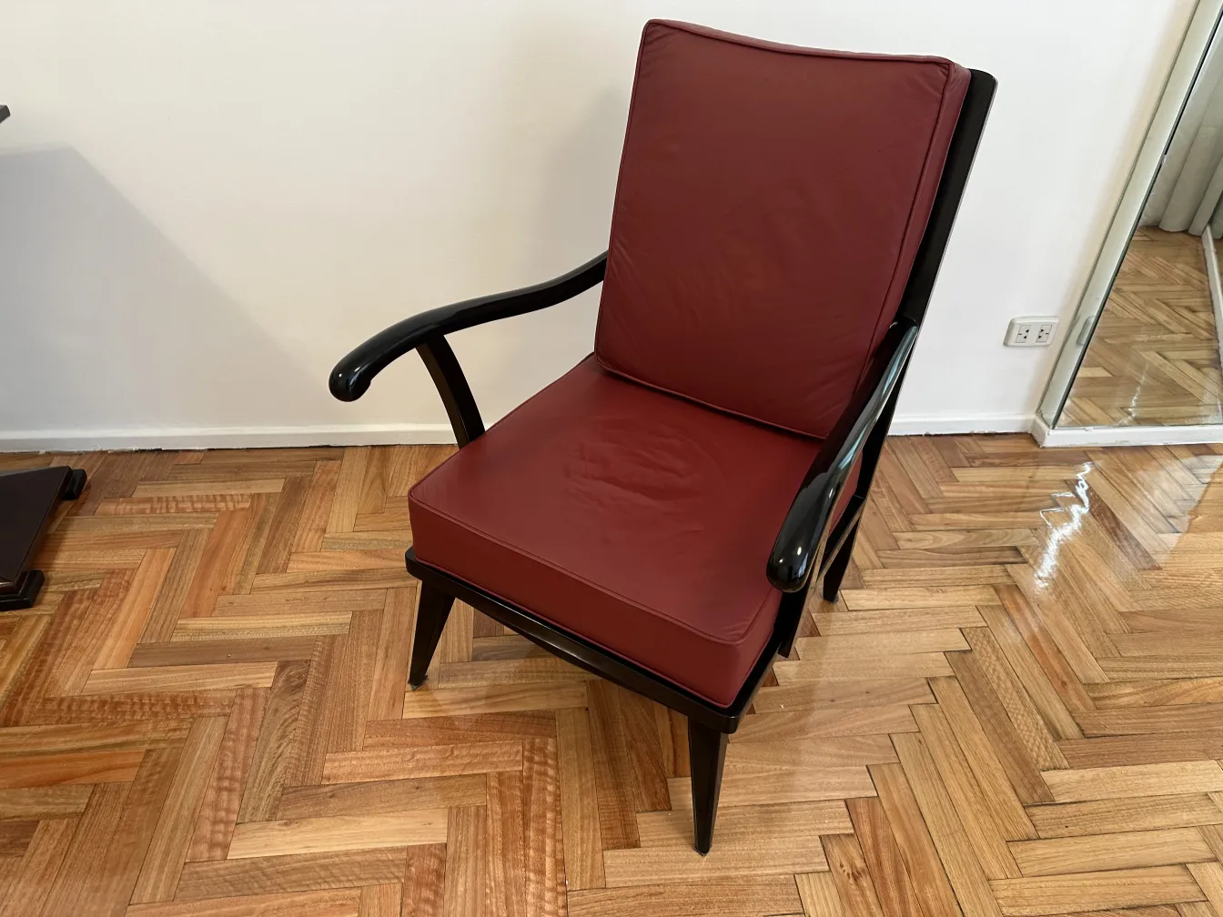 Due poltrone antiche di colore bordeaux con braccioli.