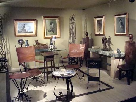 Deux fauteuils anciens dans une salle avec tableaux et décor