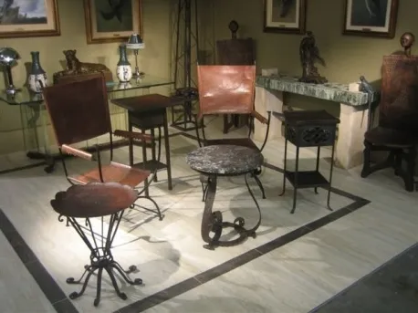 due poltrone antiche in un ambiente decorativo con luce soffusa e arte sulle pareti