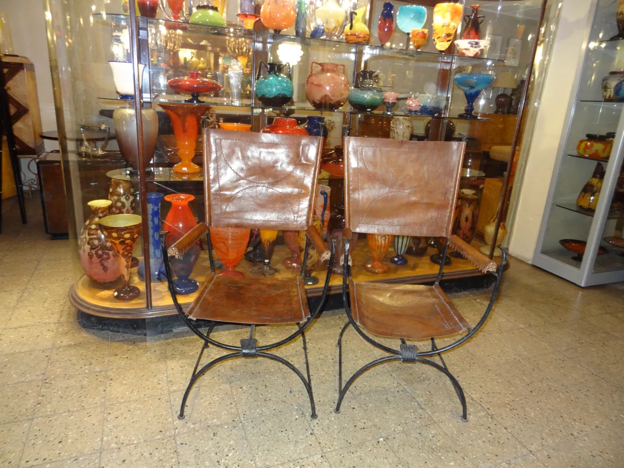 Bild von 2 antiken Armlehnstühlen vor einer bunten Vitrine