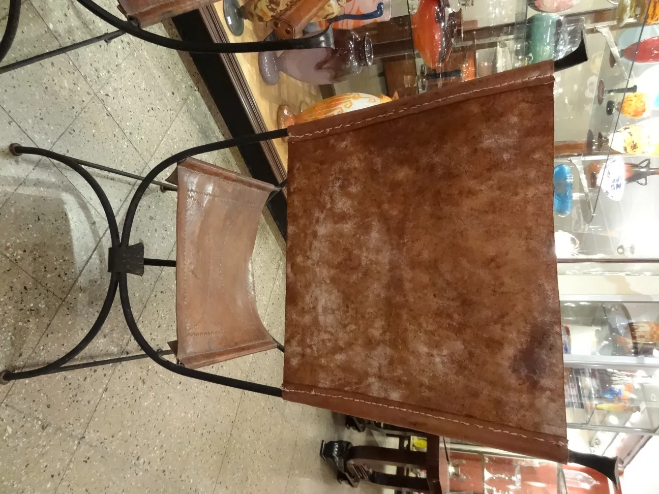 2 sillones antiguos en un ambiente decorativo, suaves tonos marrones, con un fondo de antigüedades.