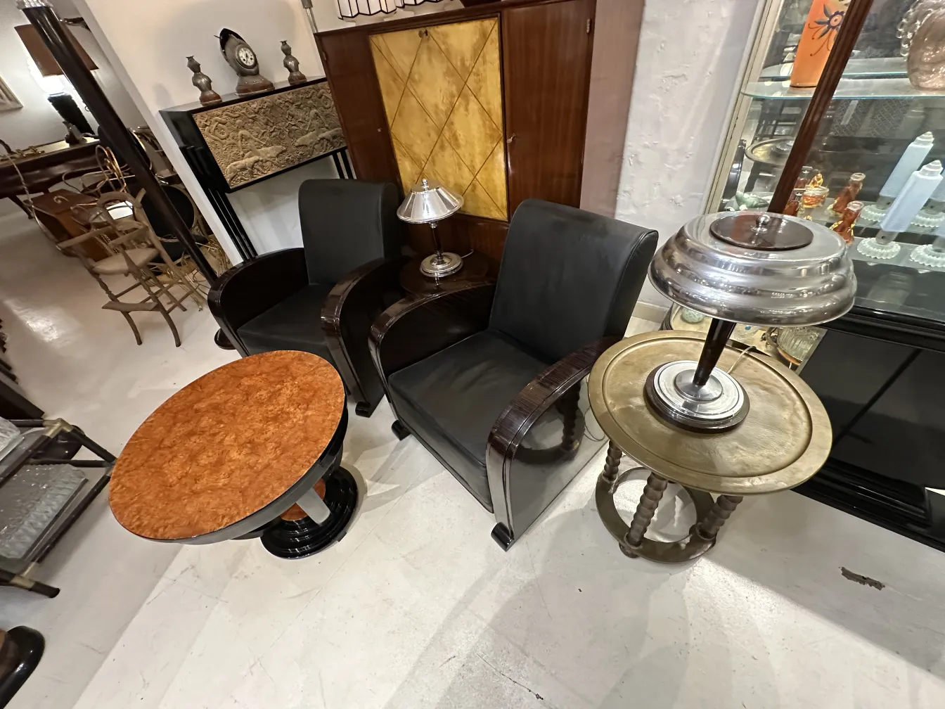 Dos sillones antiguos con lámparas y mesas pequeñas en un ambiente elegante.