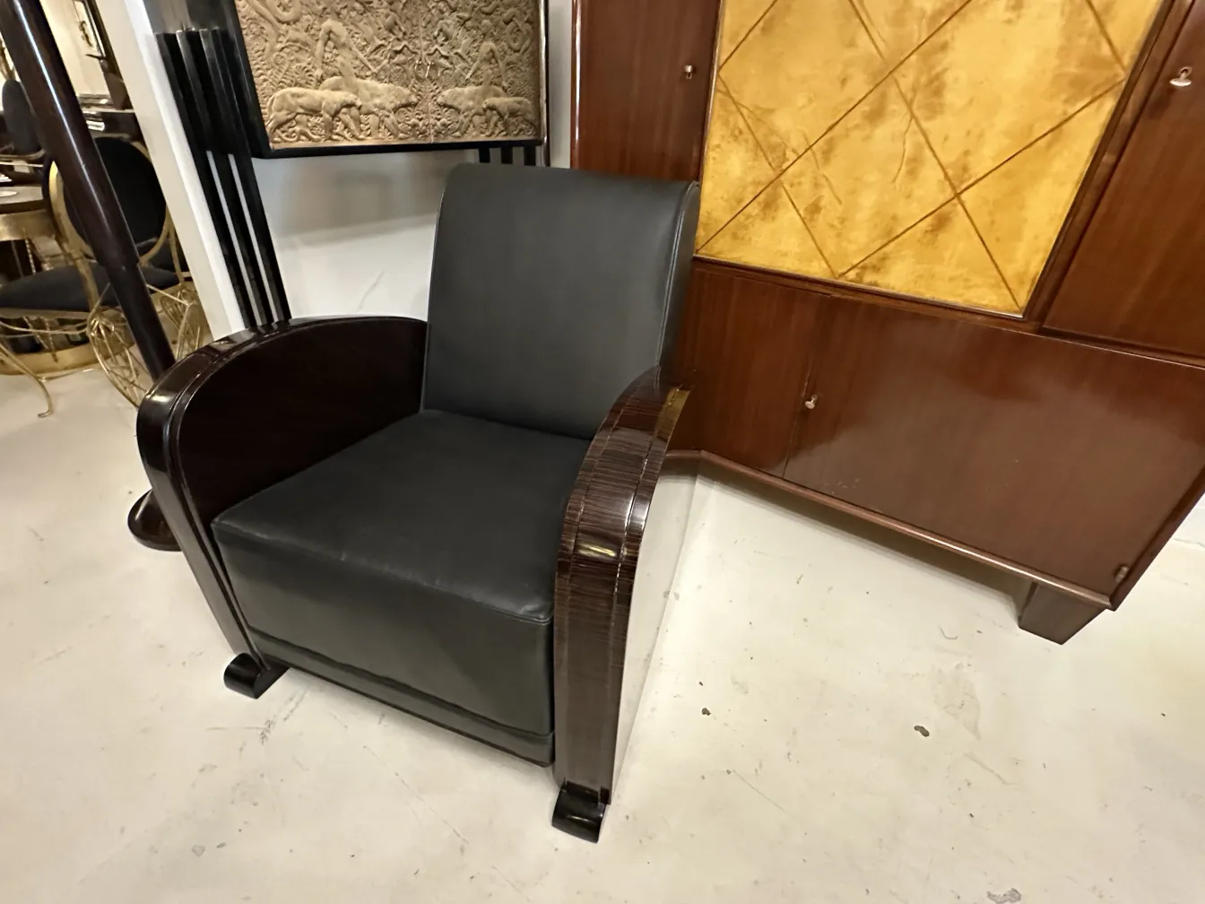 vista laterale di 2 poltrone antiche con bracci eleganti in un ambiente neutro