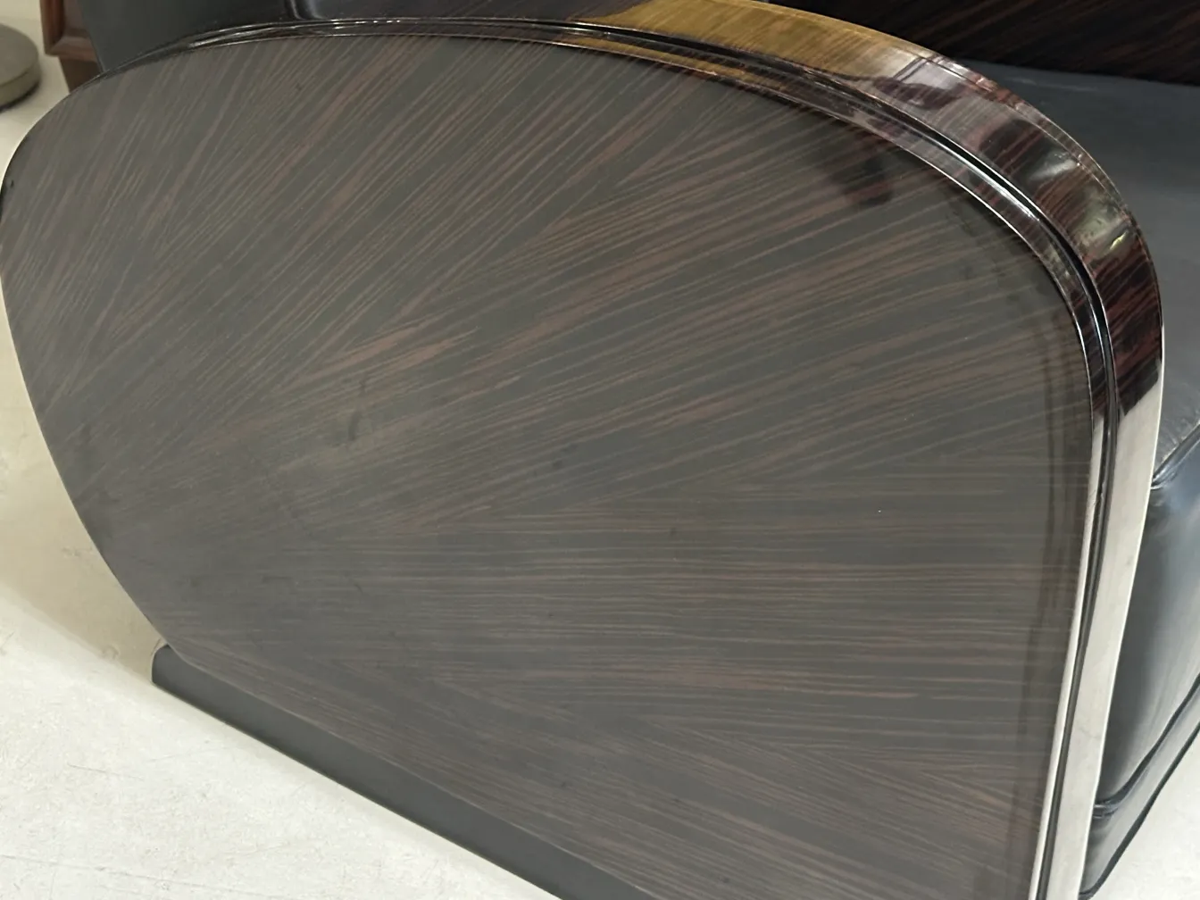 Seitenansicht von 2 antiken Armlehnstühlen mit elegantem Design und dunklen Farben.