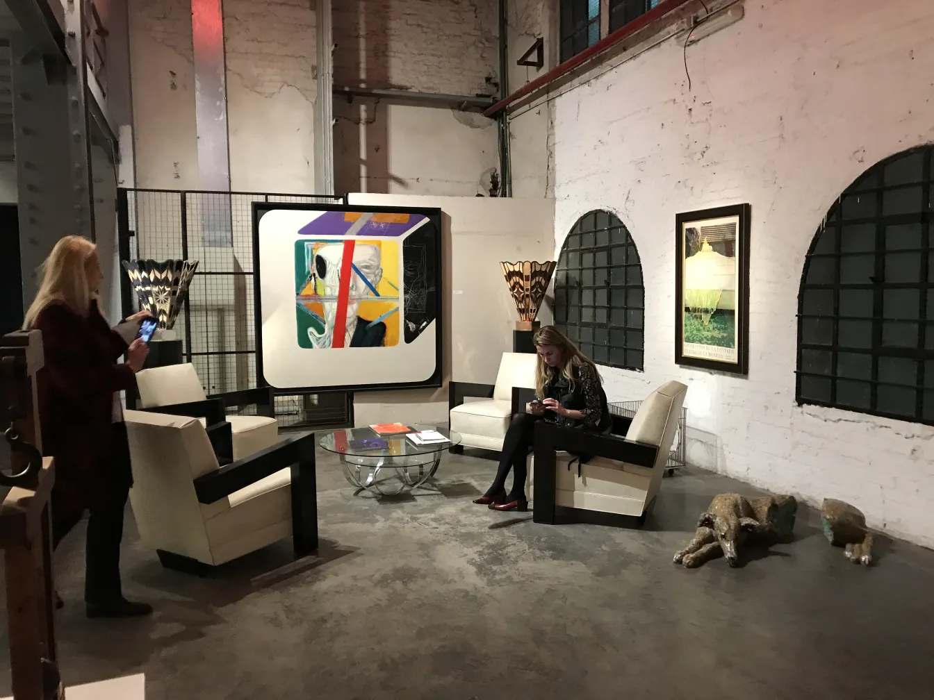 Deux fauteuils anciens au design élégant dans une salle moderne avec de l'art contemporain