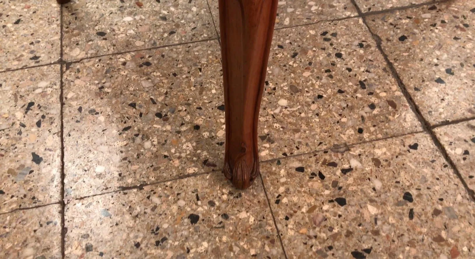 Close-up of an antique armchair leg in art nouveau style, featuring decorative details.